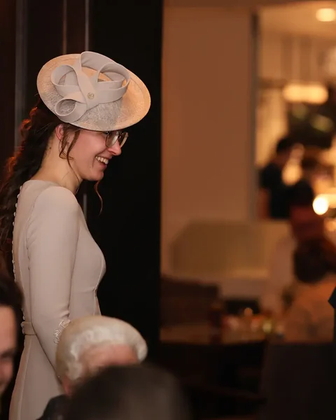 Gast met hoed op een bruiloftsreceptie